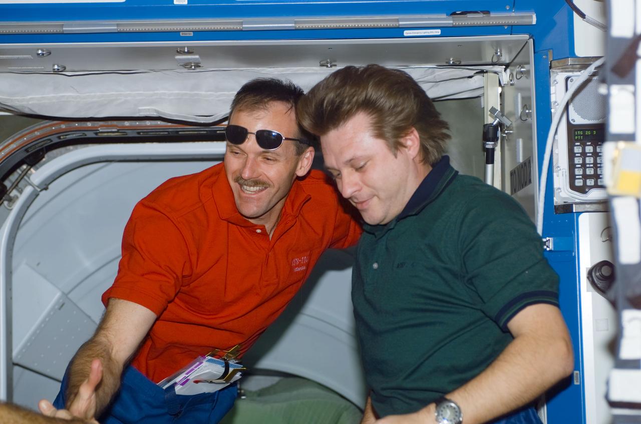 STS110-E-5097 (10 April 2002) --- Astronaut Steven L. Smith (left), STS-110 mission specialist, and cosmonaut Yury I. Onufrienko, Expedition Four mission commander, converse in the Destiny laboratory near the Pressurized Mating Adapter (PMA-2) on the International Space Station (ISS). The image was taken with a digital still camera.