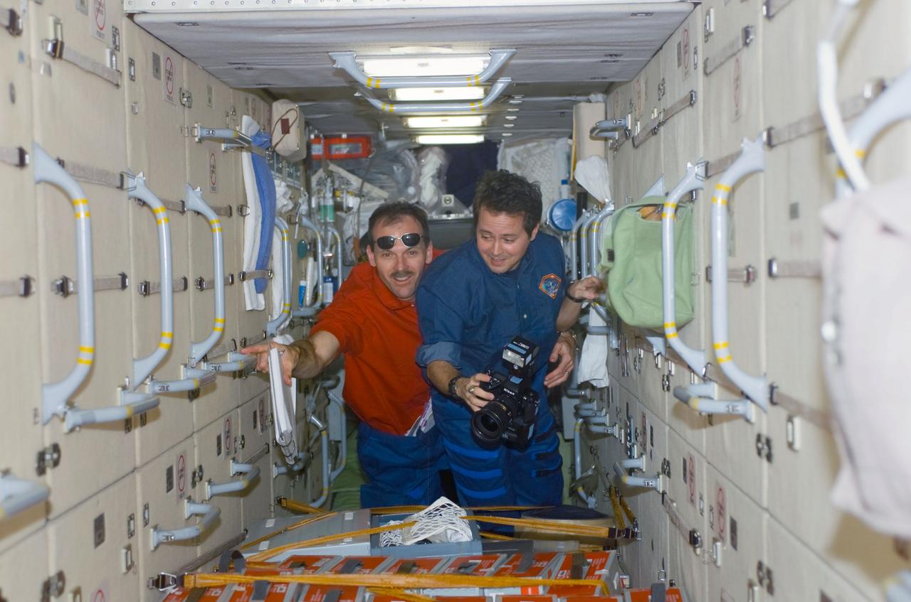 STS110-E-5115 (10 April 2002) --- Astronauts Daniel W. Bursch (right), Expedition Four flight engineer, and Steven L. Smith, STS-110 mission specialist, traverse through the functional cargo block (FGB), or Zarya on the International Space Station (ISS). The image was taken with a digital still camera.