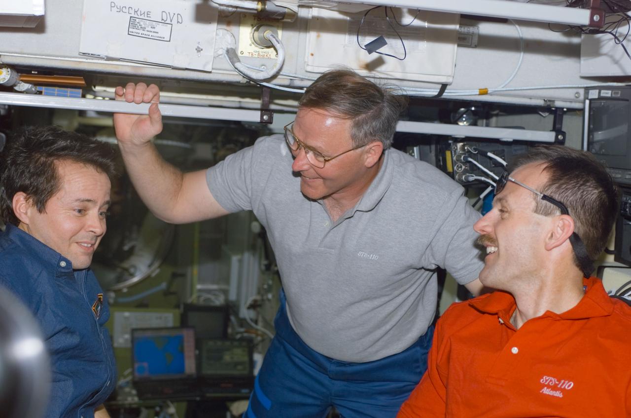 STS110-E-5122 (10 April 2002) --- Astronauts Daniel W. Bursch (left), Expedition Four flight engineer, Jerry L. Ross and Steven L. Smith, both STS-110 mission specialists, converse in the Zvezda Service Module on the International Space Station (ISS). The image was taken with a digital still camera.