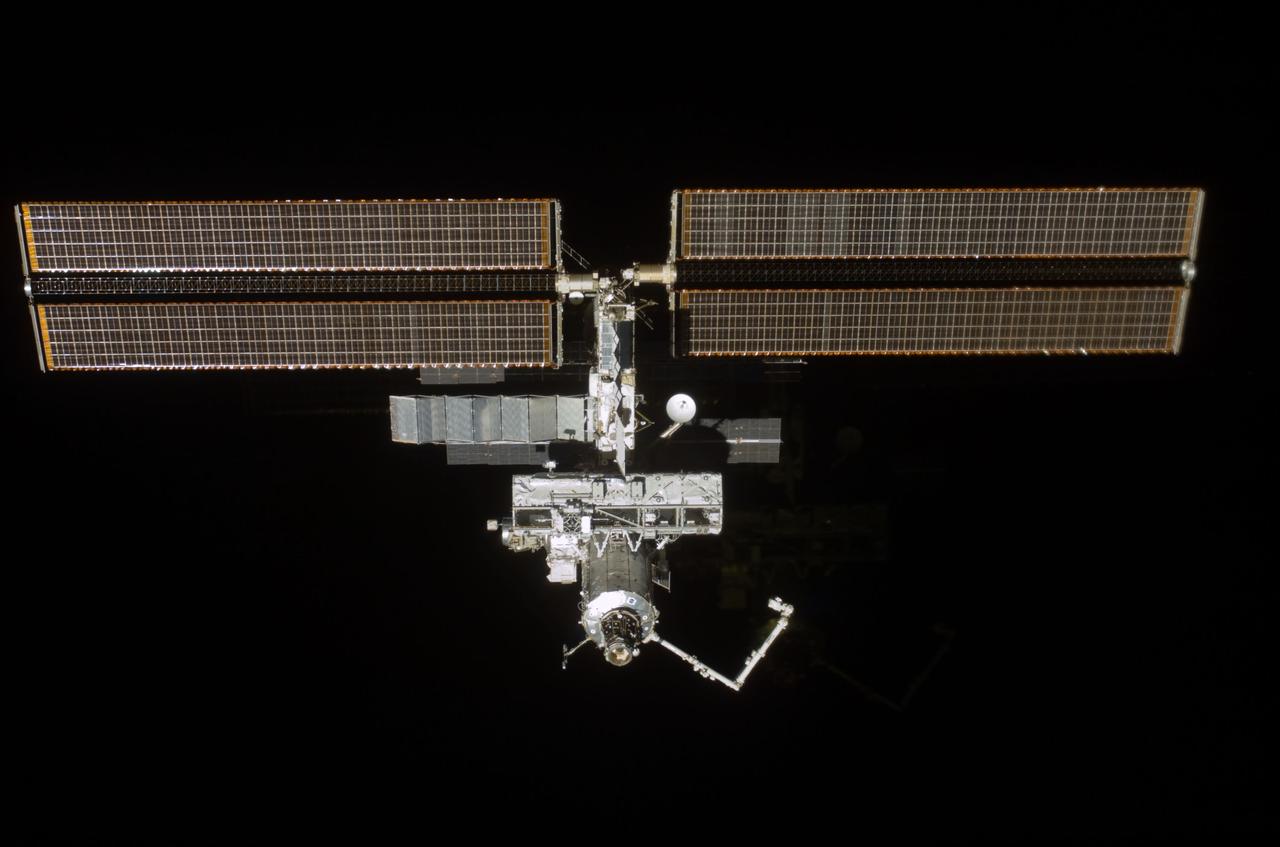 STS110-E-6006 (17 April 2002) --- The International Space Station (ISS), newly equipped with the 27,000 pound S0 (S-zero) truss, was photographed with a digital still camera by one of the astronauts on board the Space Shuttle Atlantis. Seen just above center frame, S0 is the first segment of a truss structure which will ultimately expand the station to the length of a football field. Atlantis pulled away from the complex at 1:31 p.m. (CDT) as two spacecraft flew some 247 statute miles above Earth. After more than a week of joint operations between the shuttle and station crews, astronaut Stephen N. Frick, pilot, backed Atlantis away to a distance of about 400 feet in front of the station, where he began a 1 1/4 lap flyaround of the ISS.