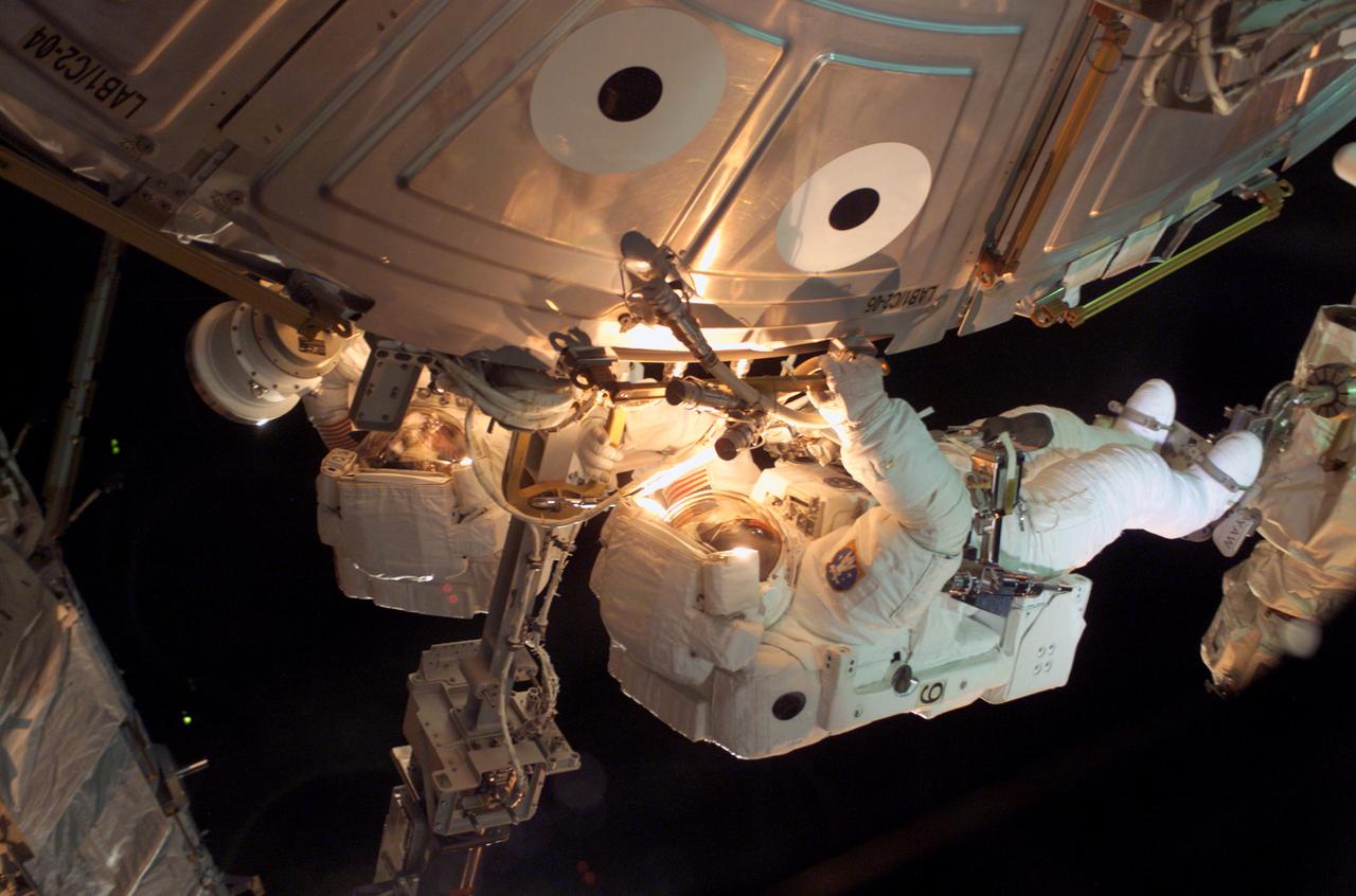 STS112-E-05295 (12 October 2002) --- Astronaut Piers J. Sellers uses both a handrail on the Destiny Laboratory and a foot restraint on the Space Station Remote Manipulator System or Canadarm2 to remain stationary while performing work at the end of the STS-112 mission's second spacewalk.