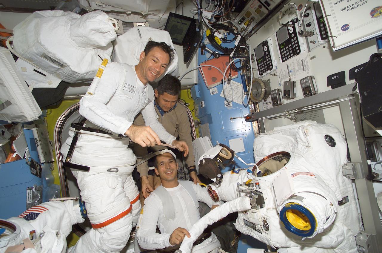 STS113-E-05290 (30 November 2002) --- Astronauts Michael E. Lopez-Alegria (left) and John B. Herrington (bottom), both STS-113 mission specialists, assisted by astronaut Paul S. Lockhart, STS-113 pilot, don their Extravehicular Mobility Unit (EMU) spacesuits in the Quest Airlock on the International Space Station (ISS). Moments later, Lopez-Alegria and Herrington went on to begin the third and final scheduled spacewalks to perform work on the International Space Station (ISS).