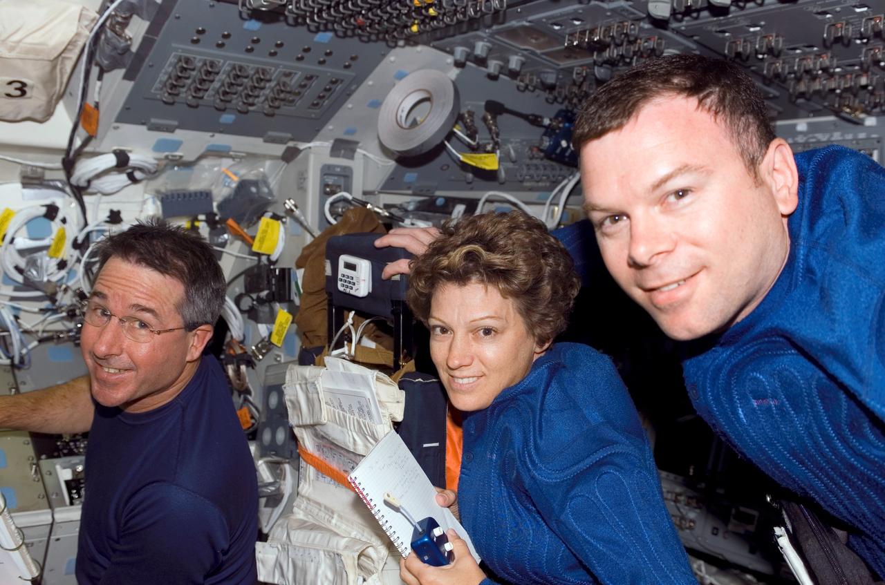 S114-E-5184 (27 July 2005) --- Among the first group of images downlinked from the Space Shuttle Discovery is this image showing astronaut Eileen M. Collins, STS-114 commander, flanked by astronauts Stephen K. Robinson (left), mission specialist, and James M. Kelly, pilot.