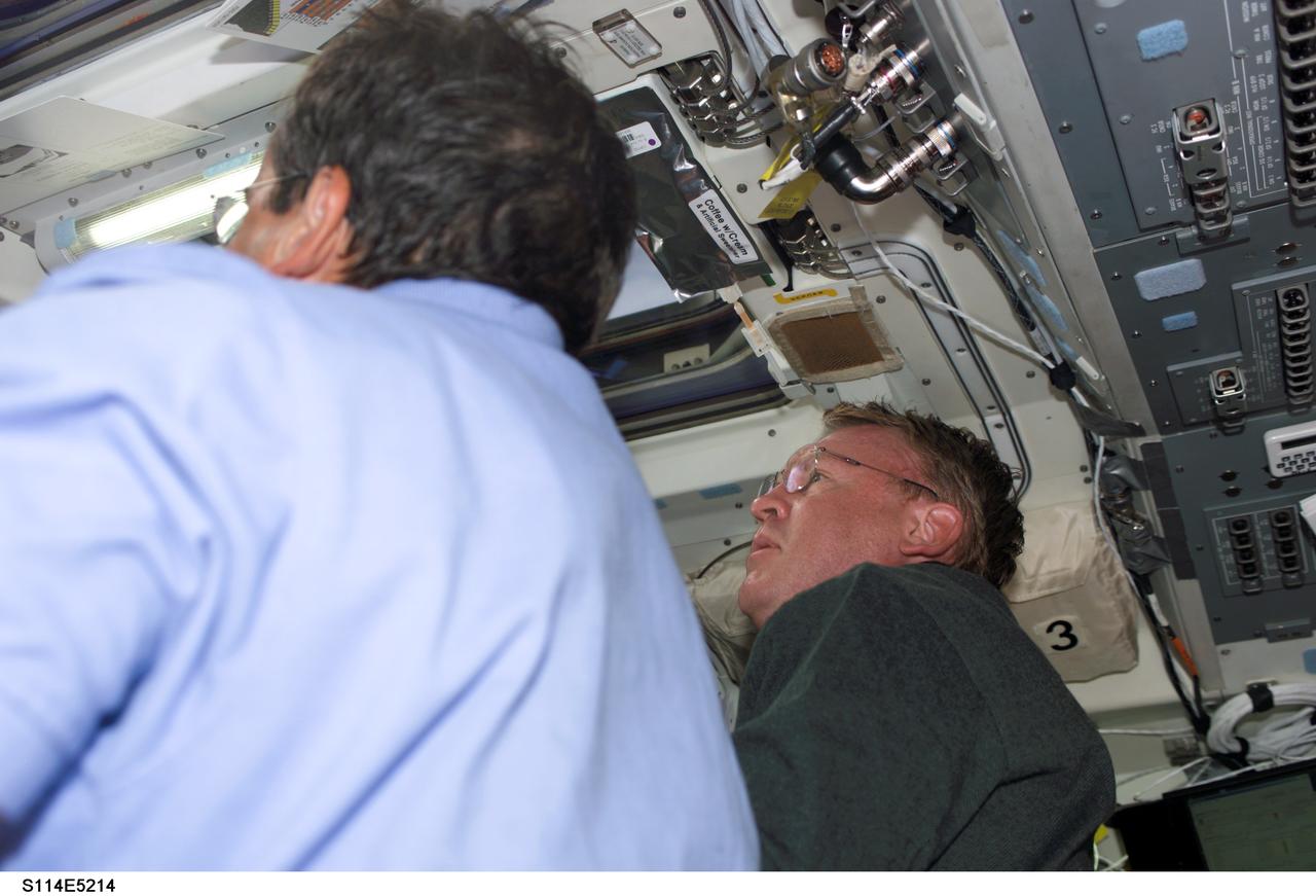 STS114-E-5214 (27 July 2005) --- Low angle view on the aft flight deck of Discovery shows astronauts Charles J. Camarda (left) and Andrew S.W. Thomas, both mission specialists, as they perform a joint task.