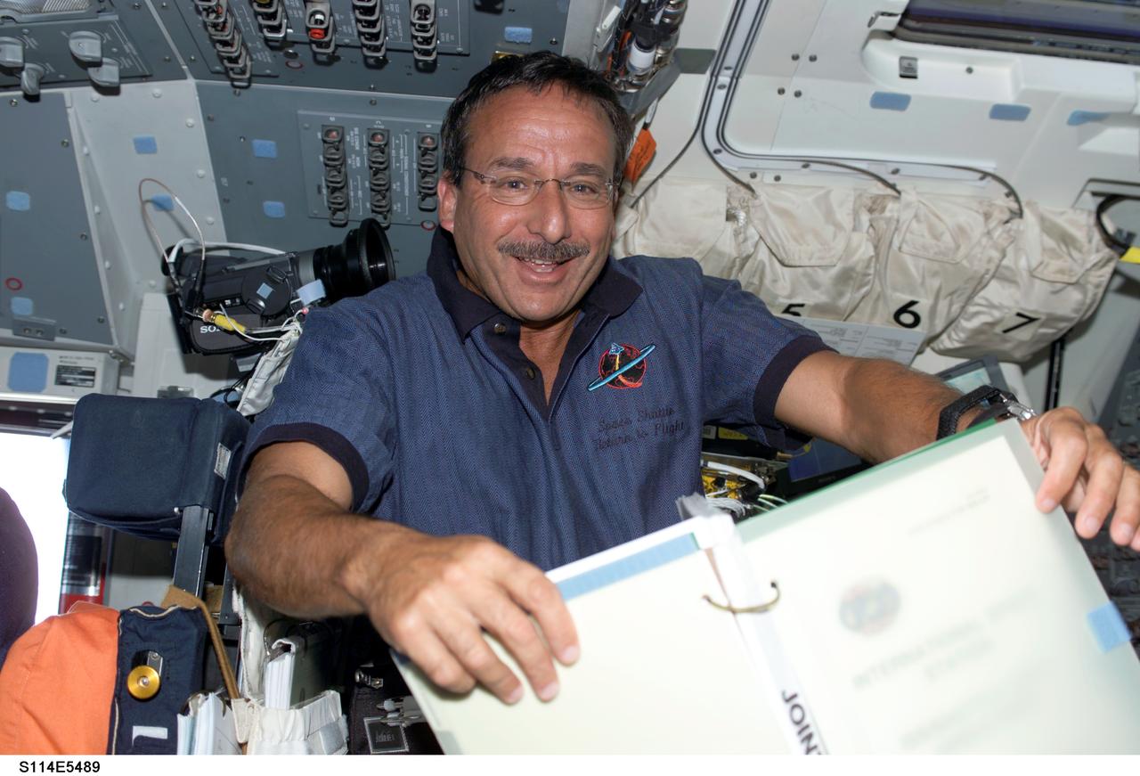 S114-E-5489 (28 July 2005) --- Astronaut Charles J. Camarda, STS-114 mission specialist, refers to a procedures checklist on Discovery's aft flight deck. This third day of on-orbit activities is dedicated primarily to rendezvous and docking activities and followup operations.
