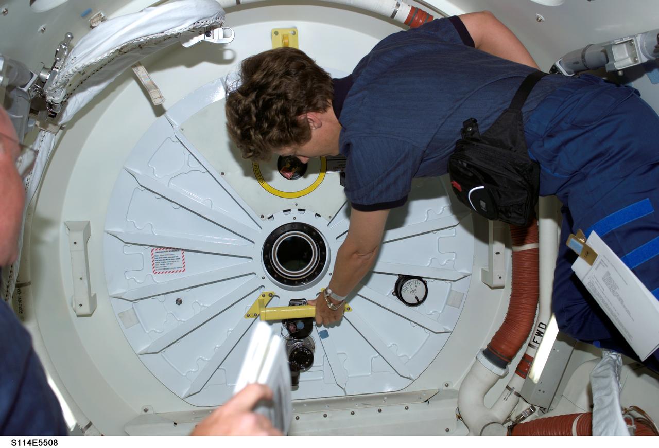 S114-E-5508 (28 July 2005) --- Astronaut Eileen M. Collins, STS-114 commander, prepares to open the hatch that will lead her and the entire Discovery crew into the International Space Station. This was just one highlight of a very busy day that earlier saw the flawless rendezvous and docking operations between the shuttle and the orbital outpost.