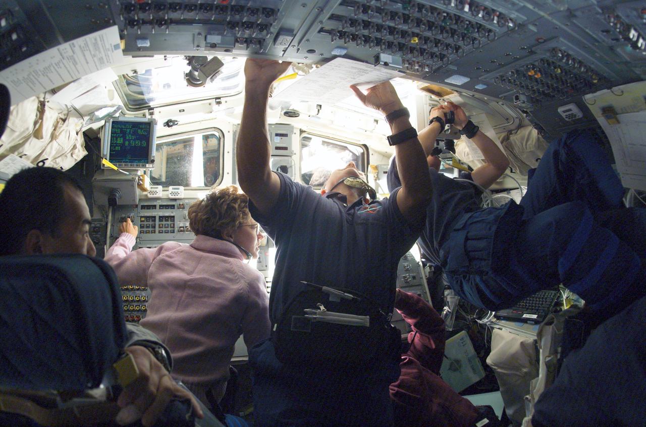 S114-E-5656 (28 July 2005) --- The STS-114 crew works on the aft flight deck of the Space Shuttle Discovery during rendezvous and docking procedures with the international space station. Astronaut Eileen M. Collins, commander, is visible at the aft flight deck controls. Also onboard were astronauts James M. Kelly, pilot; Japan Aerospace Exploration Agency (JAXA) astronaut Soichi Noguchi, Stephen K. Robinson, Andrew S. W. Thomas, Wendy B. Lawrence and Charles J. Camarda, all mission specialists.