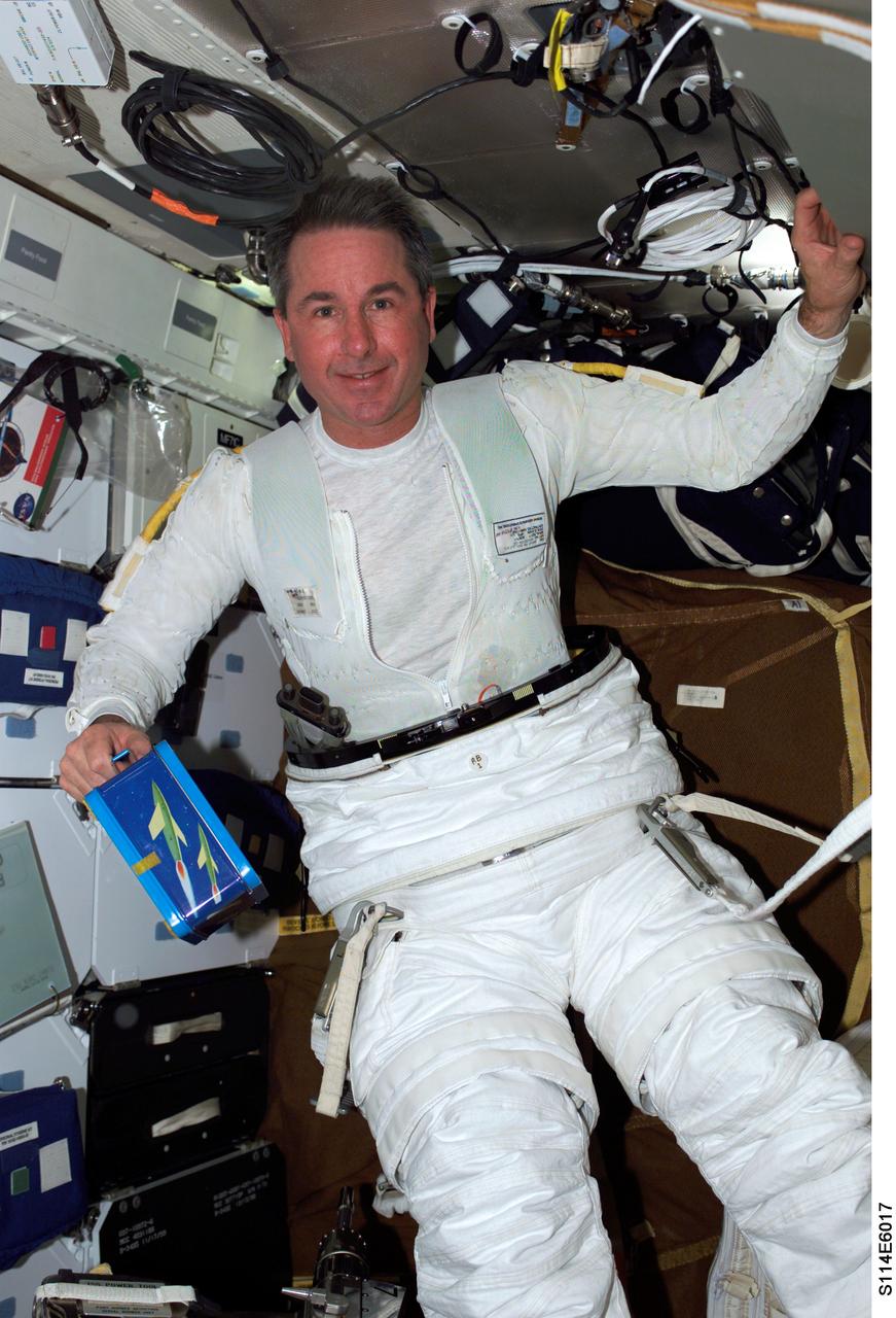 S114-E-6017 (1 August 2005) --- Astronaut Stephen K. Robinson, STS-114 mission specialist, dons his Extravehicular Mobility Unit (EMU) space suit on the middeck of the Space Shuttle Discovery, as he prepares for the scheduled seven-hour space walk with fellow STS-114 mission specialist, astronaut Soichi Noguchi (out of frame) representing Japan Aerospace Exploration Agency (JAXA).