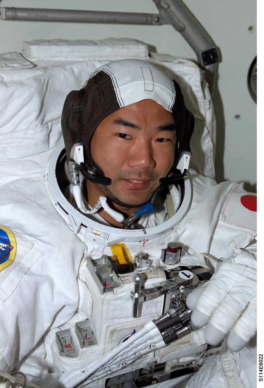 S114-E-6022 (1 August 2005) --- Astronaut Soichi Noguchi, representing the Japan Aerospace Exploration Agency (JAXA), attired in his Extravehicular Mobility Unit (EMU) space suit on the middeck of the Space Shuttle Discovery, prepares for the scheduled seven-hour space walk with fellow STS-114 mission specialist, astronaut Stephen K. Robinson (out of frame).