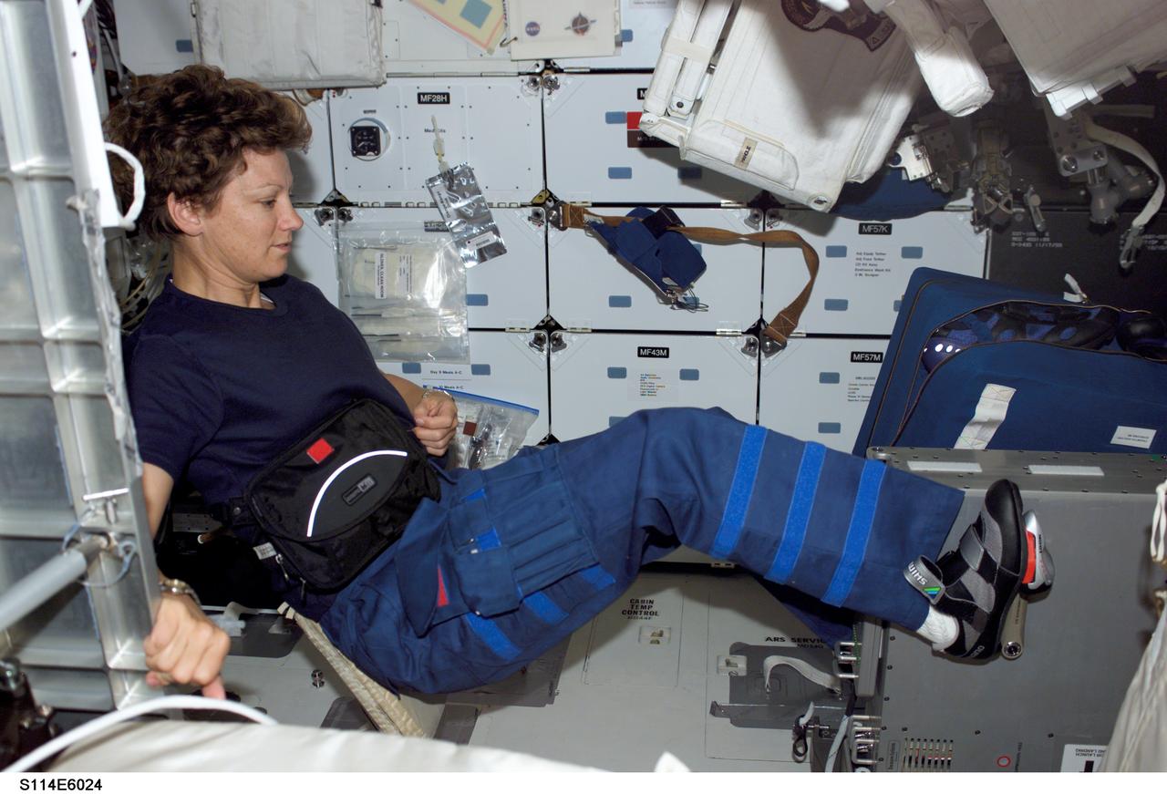S114-E-6024 (1 August 2005) --- Astronaut Eileen M. Collins, STS-114 commander, works out on the bicycle ergometer on the Space Shuttle Discovery's middeck.