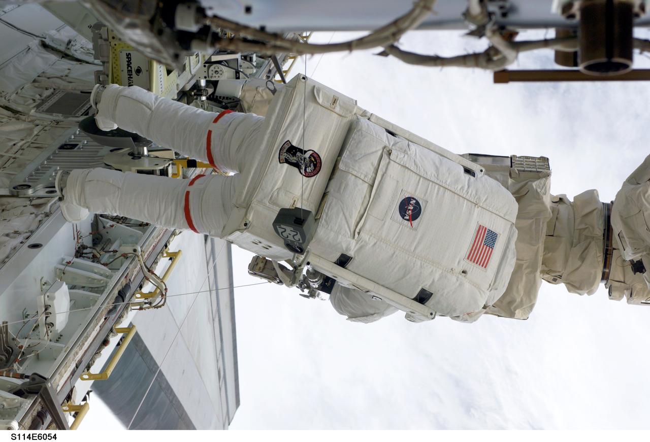 S114-E-6054 (30 July 2005) --- Astronaut Soichi Noguchi, STS-114 mission specialist representing Japan Aerospace Exploration Agency (JAXA), participates in the mission&#0146;s first scheduled session of extravehicular activity (EVA). Noguchi and crewmate Stephen K. Robinson (out of frame) completed a demonstration of Shuttle thermal protection repair techniques and enhancements to the International Space Station&#0146;s attitude control system during the successful 6-hour, 50-minute spacewalk.