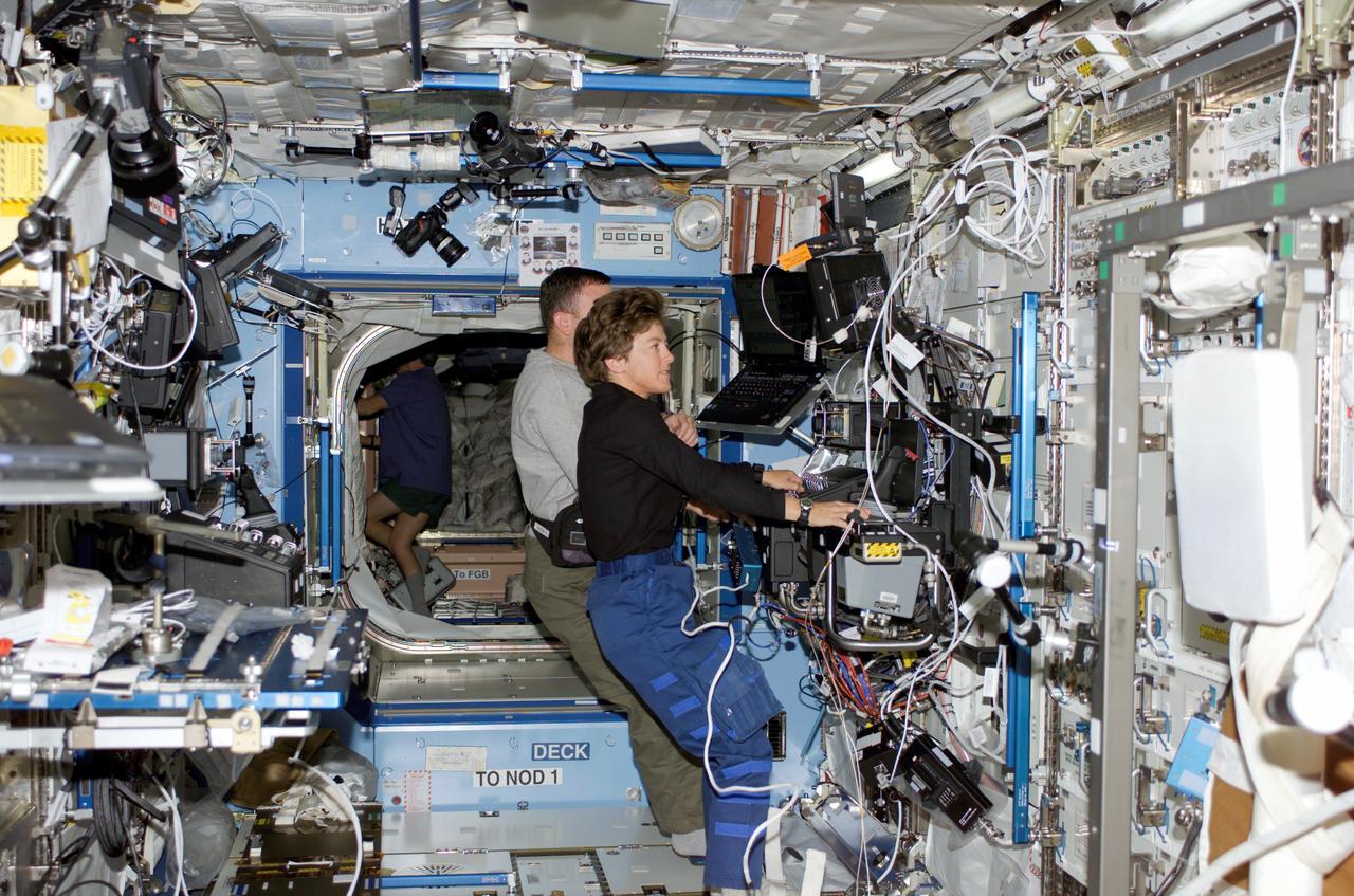 S114-E-6124 (31 July 2005) --- Astronauts Wendy B. Lawrence (foreground), STS-114 mission specialist, and James M. Kelly, pilot, work the controls of the Space Station Remote Manipulator System (SSRMS) or Canadarm2 in the Destiny laboratory of the international space station.