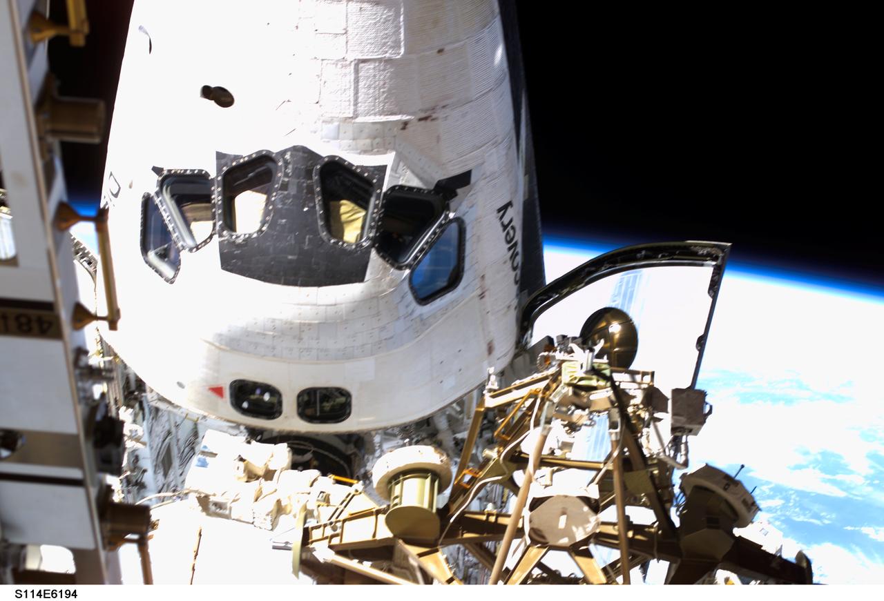S114-E-6194 (3 August 2005) --- This picture of the forward section of the Space Shuttle Discovery docked to the International Space Station was taken by Japan Aerospace Exploration Agency Astronaut Soichi Noguchi during the third and final spacewalk for the STS-114 mission.  Both Noguchi and his crewmate Astronaut Stephen K. Robinson were equipped with digital still cameras on the spacewalks.