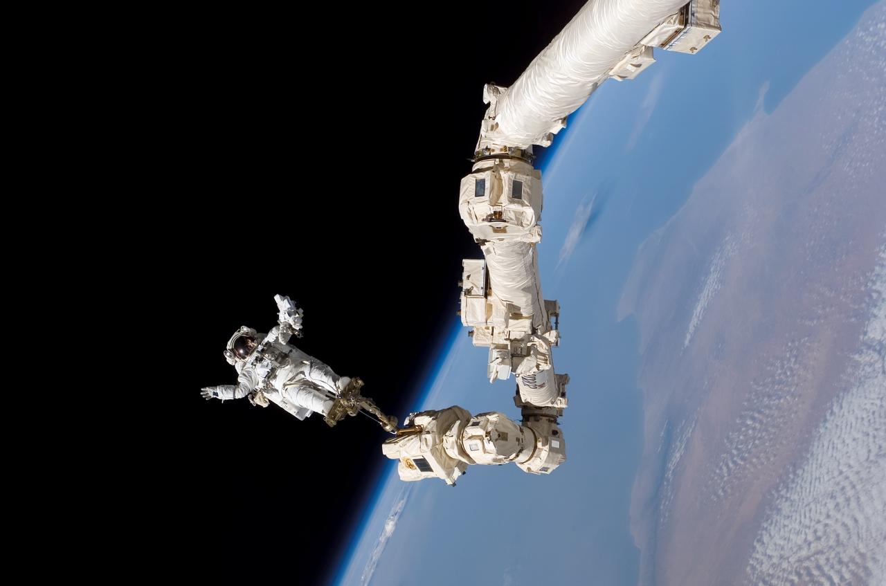 S114-E-6642 (3 Aug. 2005) --- Astronaut Stephen K. Robinson, STS-114 mission specialist, anchored to a foot restraint on the International Space Station’s Canadarm2, participates in the mission’s third session of extravehicular activity (EVA). The blackness of space and Earth’s horizon form the backdrop for the image.