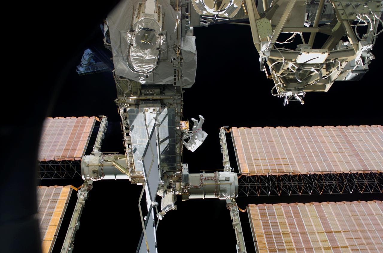 S114-E-6856 (3 August 2005) --- Backdropped by the blackness of space, astronaut Soichi Noguchi, STS-114 mission specialist representing the Japan Aerospace Exploration Agency (JAXA), traverses along the P6 truss near the arrays on the international space station during the mission’s third session of extravehicular activity (EVA).