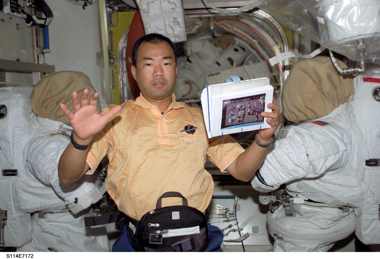 S114-E-7172 (5 August 2005) --- Astronaut Soichi Noguchi, STS-114 mission specialist representing Japan Aerospace Exploration Agency (JAXA), holds a procedures checklist in the Quest Airlock of the International Space Station. The crewmembers were making final preparations for Space Shuttle Discovery&#0146;s scheduled departure on August 6.