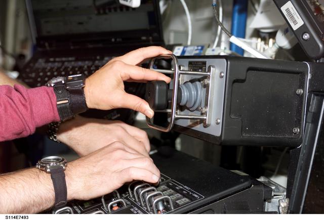 NASA image: Lawrence and Kelly's hands on controls in the Destiny laboratory module