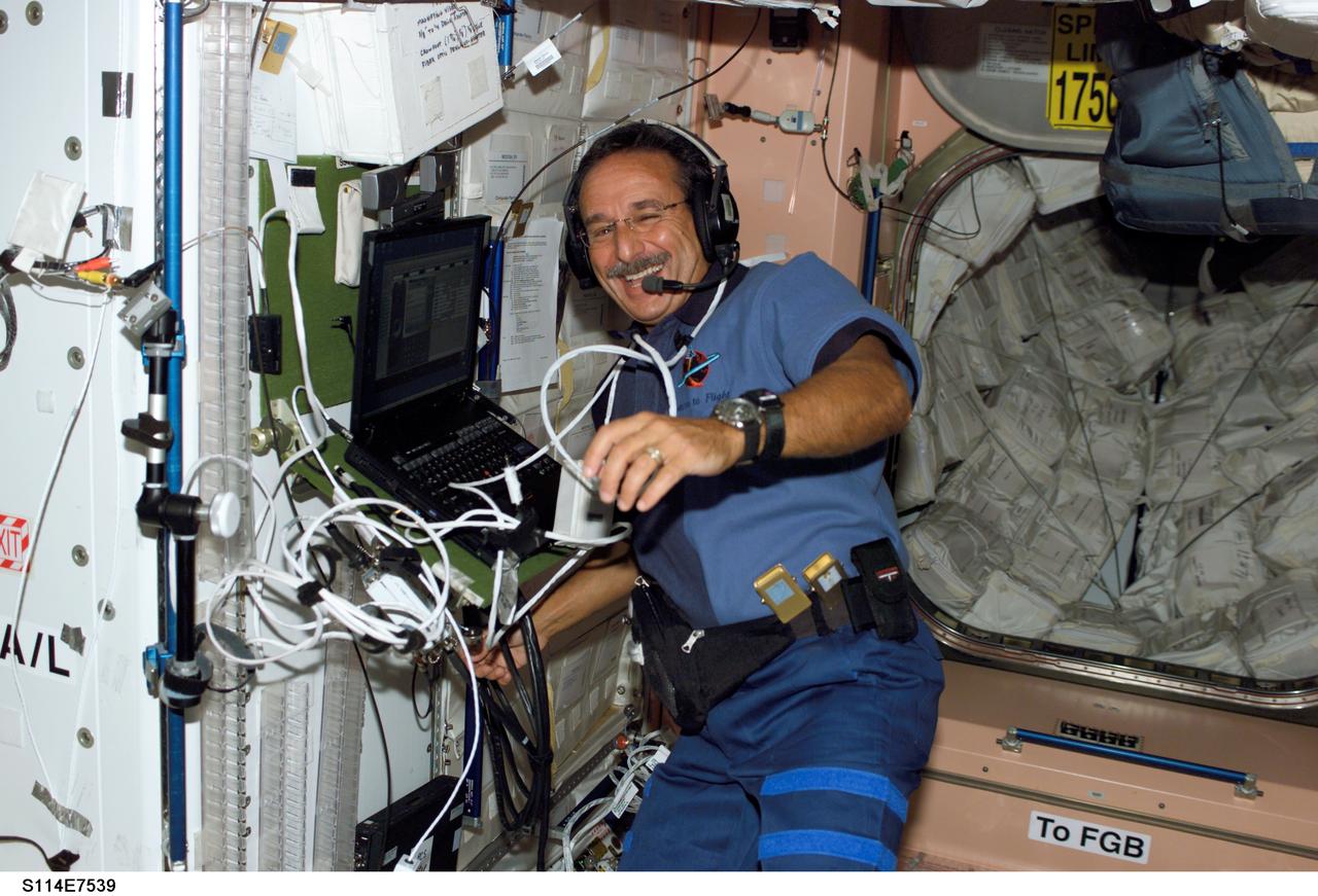 S114-E-7539 (6 August 2005) --- Astronaut Charles J. Camarda, STS-114 mission specialist, uses a communication system in the Unity node of the International Space Station while Space Shuttle Discovery was docked to the Station.
