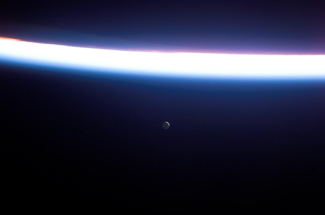 S114-E-7558 (6 August 2005) --- This view featuring a distant Moon and a line of airglow of Earth’s atmosphere was photographed by an STS-114 crewmember onboard the Space Shuttle Discovery after departure from the international space station.
