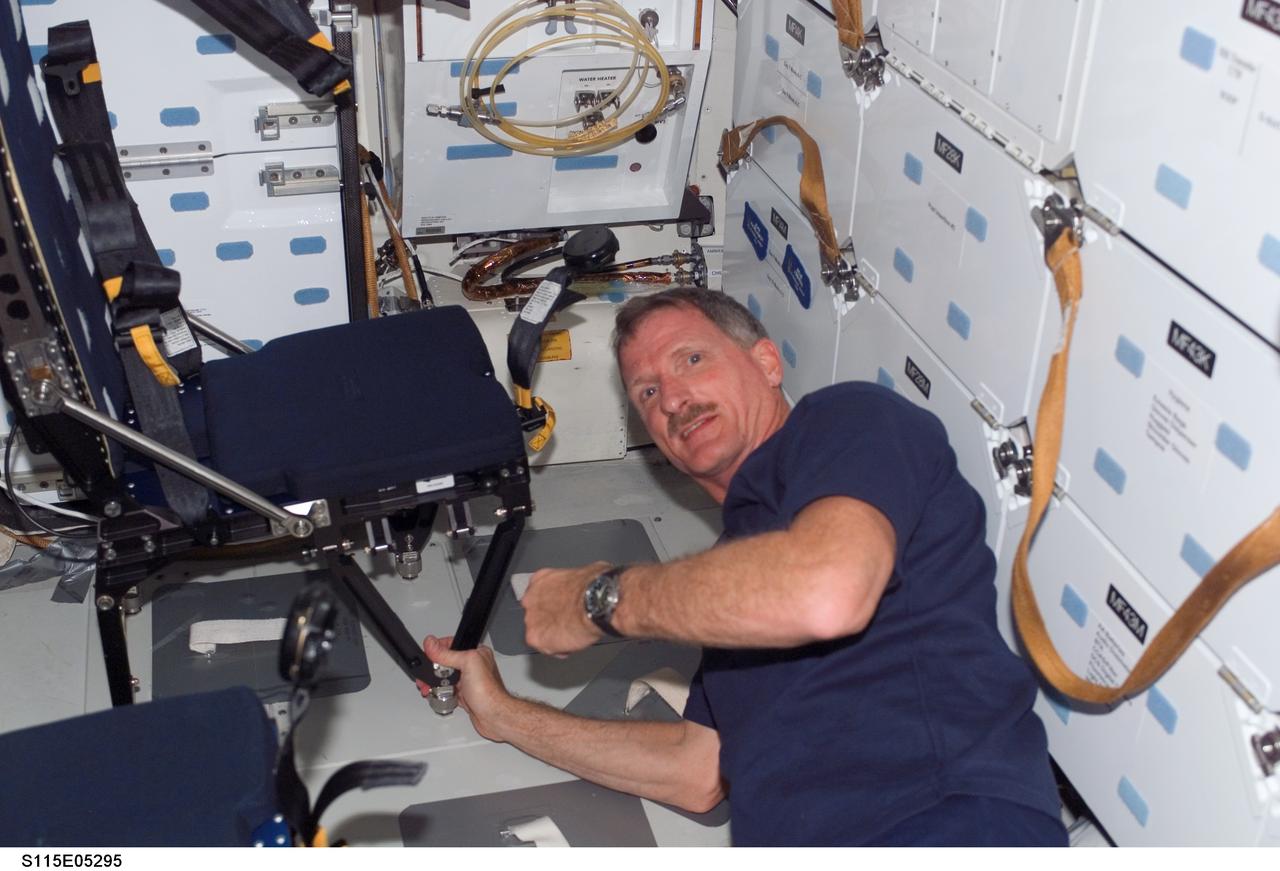 S115-E-05295 (9 Sept. 2006) --- Astronaut Joseph R. Tanner, STS-115 mission specialist,  prepares to remove one of the launch and entry seats on mid deck of Atlantis soon after the crew reached Earth orbit.  Atlantis and its crew will see a busy number of days before the mid deck seats get re-deployed for entry and landing.