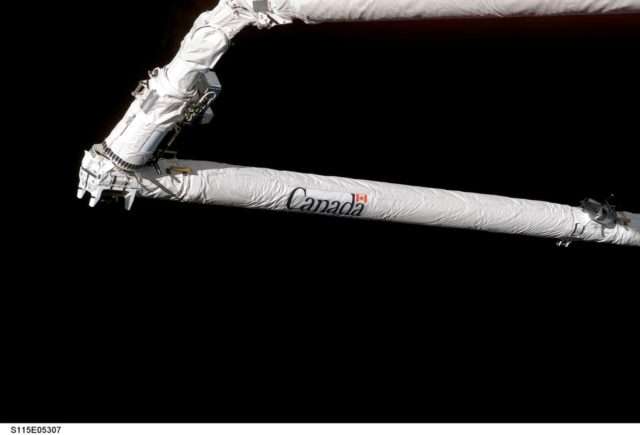 S115-E-05307 (10 Sept. 2006) --- As in the case of the previous two shuttle missions, a tandem of the orbiter boom sensor system (OBSS) and the remote manipulator system (RMS) arm conducts a survey of the thermal protection system on the Space Shuttle Atlantis.