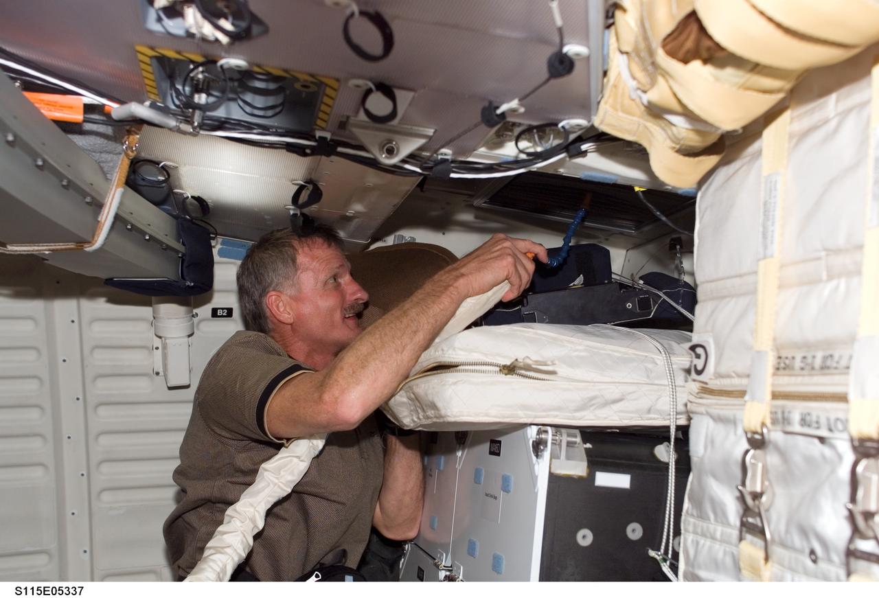 S115-E-05337 (10 Sept. 2006) --- Astronaut Joseph R. Tanner, STS-115 mission specialist, works on the middeck of the Space Shuttle Atlantis on the eve of docking day with the International Space Station.