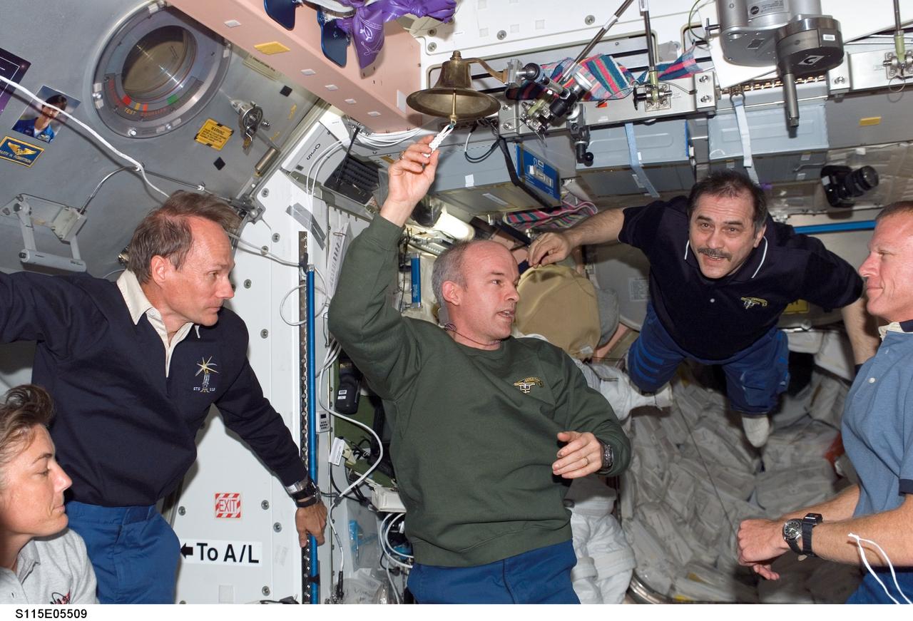 S115-E-05509 (11 Sept. 2006) --- Expedition 13 and STS-115 crewmembers reunite onboard the International Space Station soon after its docking with the Space Shuttle Atlantis. Cosmonaut Pavel Vinogradov, Expedition 13 commander representing Russia's Federal Space Agency, floats into the aft end of Unity from one of the pressurized mating adapters (PMA-1). Vinogradov's crewmate, astronaut Jeffrey N. Williams, flight engineer and NASA space station science officer, is in center frame. Canadian astronaut Steven G. MacLean (second left) is standing in the hatch to Quest, next to astronaut Heidemarie M. Stefanyshyn-Piper, mission specialist oon the Atlantis crew. Astronaut Brent W. Jett Jr., the shuttle mission's crew commander, is at right.