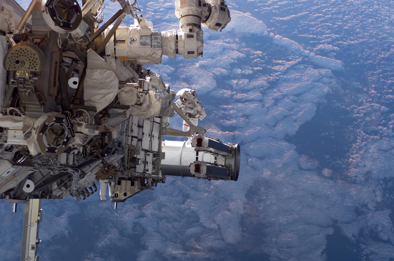 S115-E-05554 (12 Sept. 2006) --- Astronauts Joseph R. Tanner (image center) and Heidemarie M. Stefanyshyn-Piper (partially obscured, lower left), both STS-115 mission specialists, participate in the first of three sessions of extravehicular activity (EVA) as construction resumes on the International Space Station.