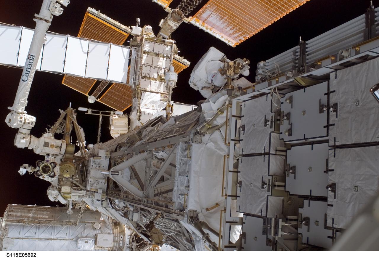 S115-E-05692 (12 Sept. 2006) --- Astronaut Joseph R. Tanner (top center), STS-115 mission specialist, works near the Solar Alpha Rotary Joint (SARJ) during the Sept. 12 spacewalk, which he shared with astronaut Heidemarie M. Stefanyshyn-Piper (out of frame).  The two participated in the first of three scheduled STS-115 extravehicular activity (EVA) sessions as the Atlantis astronauts and the Expedition 13 crew members join efforts this week to resume construction of the International Space Station.