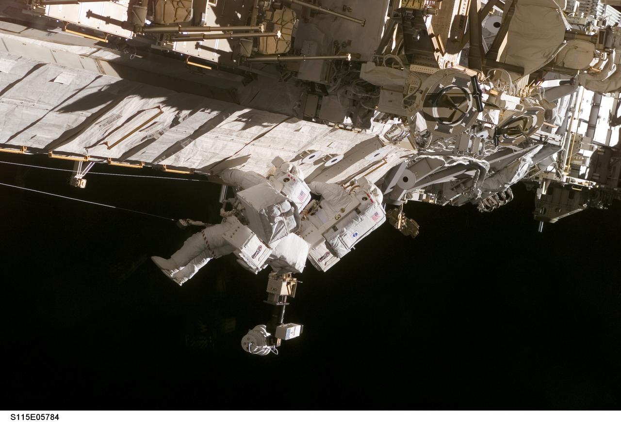 S115-E-05784 (13 Sept. 2006) --- Astronauts Daniel C. Burbank (right) and Steven G. MacLean, representing the Canadian Space Agency, participate in the second of three scheduled space walks for the Space Shuttle Atlantis and International Space Station crewmembers as construction resumes on the orbital outpost. The two STS-115 mission specialists are translating along the side of one of the station's trusses.