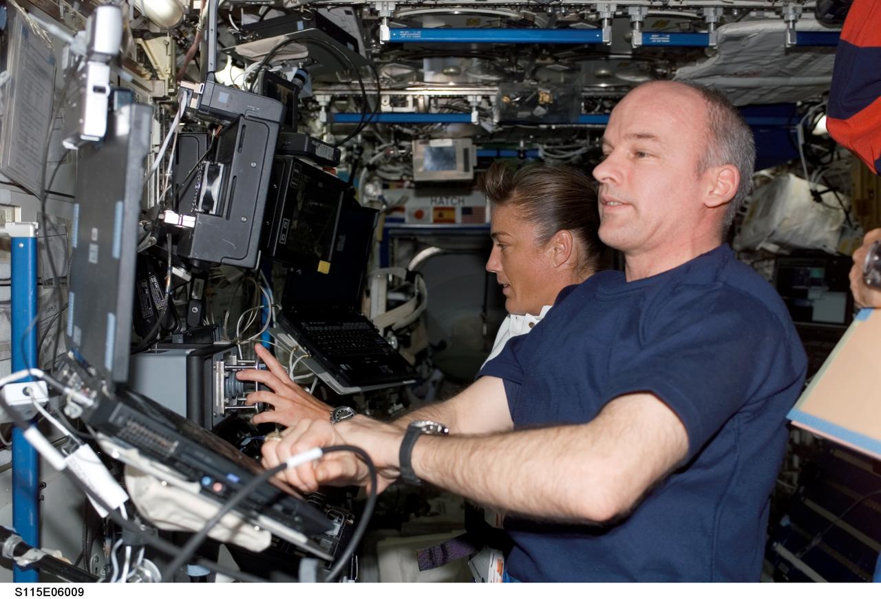S115-E-06009 (14 Sept. 2006) --- Astronauts Heidemarie M. Stefanyshyn-Piper, STS-115 mission specialist, and astronaut Jeffrey N. Williams, Expedition 13 flight engineer and NASA station science officer, work with the controls for the Canadarm2 in the Destiny laboratory aboard the International Space Station