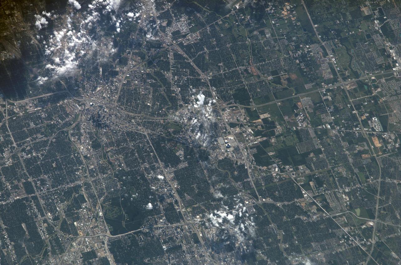 S115-E-06158 (15 Sept. 2006) --- This image of Houston's "downtown" and "uptown" districts and most of the area inside the I-610 Loop was photographed by one of the STS-115 crewmembers aboard the Space Shuttle Atlantis. Harris County Domed Stadium and the nearby facility for the National Football League's American Conference Houston representatives are just below the scattered cloud patch at frame center. What has become known as "uptown" Houston is in the lower left corner. The central business district or downtown is in the upper left quadrant, easily identified by the skyscrapers and the facilities for Houston's Major League Baseball and National Basketball Association affiliates. The Medical Center district is near the cloud patch just north of the older domed stadium. NASA is too far south to appear in the picture, though the southern leg of Beltway 8, about six miles north of the Johnson Space Center, appears at right edge; and Bush Intercontinental Airport is too far north.