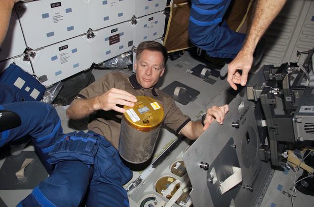 NASA image: Ferguson changes out lithium hydroxide canister in the Space Shuttle Atlantis MDDK during Expedition 13 / STS-115 Joint Operations