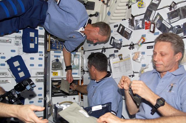 NASA image: STS-115 and Expedition 13 crewmembers eating on the FWD MDDK of the Space Shuttle Atlantis