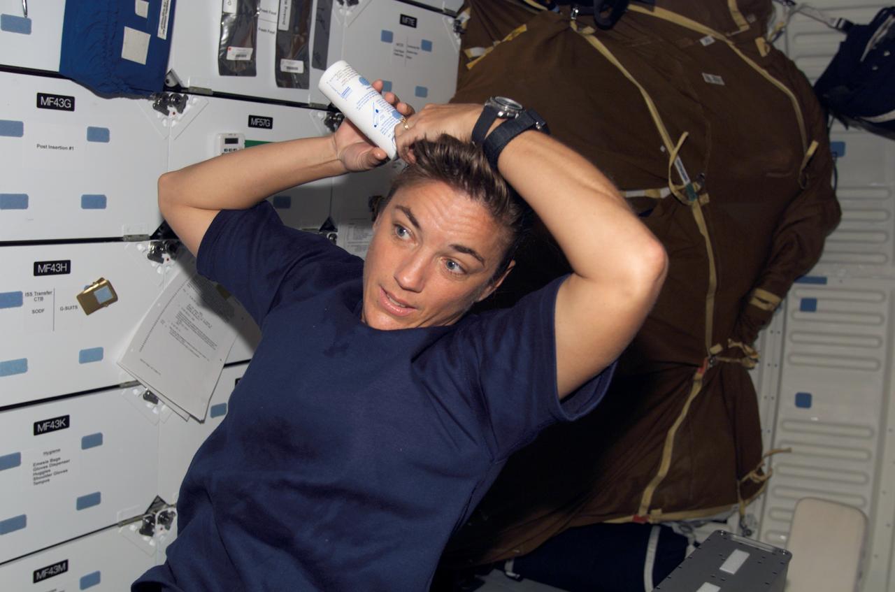 S115-E-07208 (19 Sept. 2006) --- Astronaut Heidemarie M. Stefanyshyn-Piper, STS-115 mission specialist, washes her hair on the middeck of the Space Shuttle Atlantis.