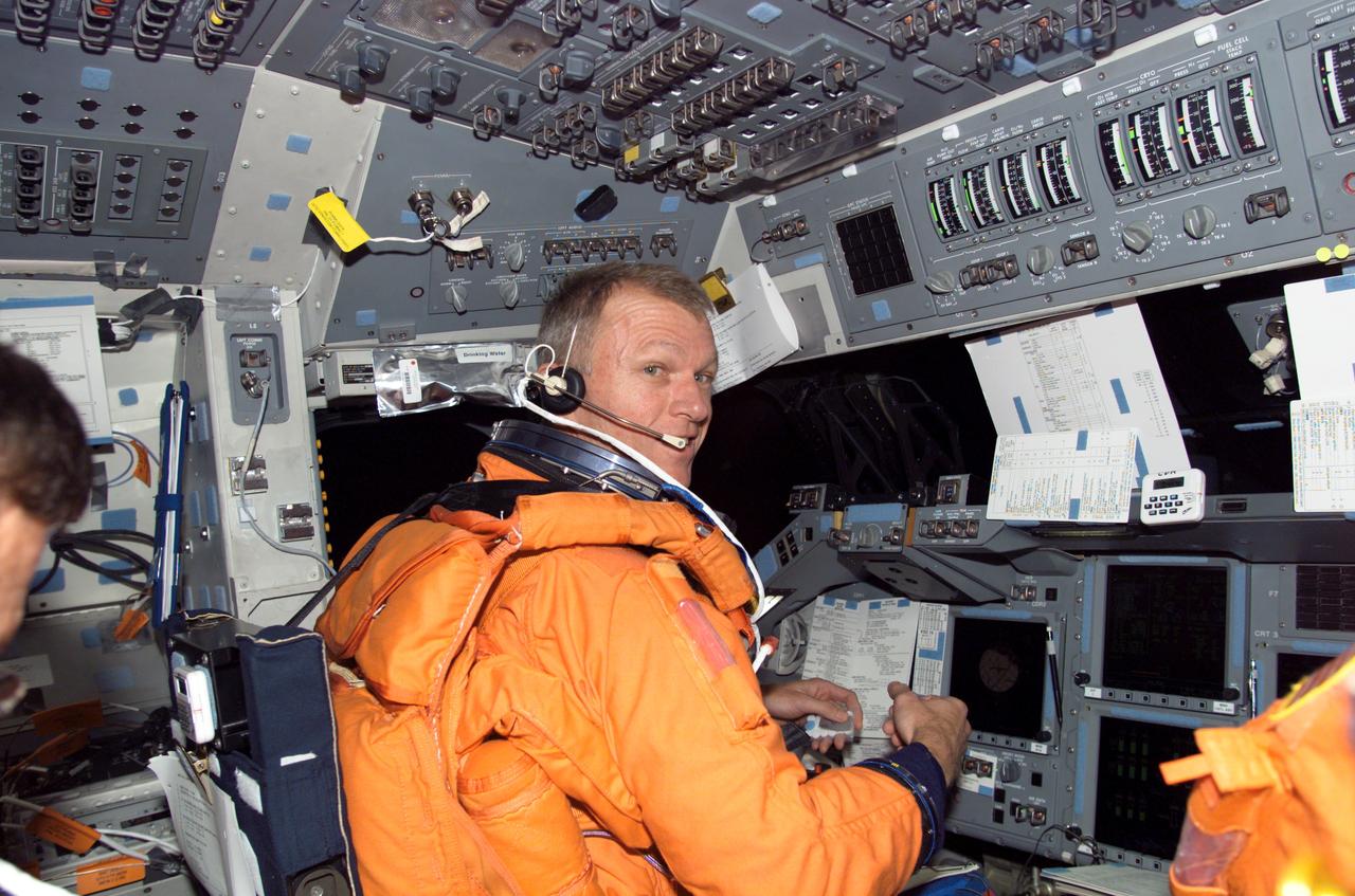 S115-E-07958 (21 Sept. 2006) --- Attired in his shuttle launch and entry suit, astronaut Brent W. Jett, Jr., STS-115 commander, looks over a procedures checklist as he occupies the commander's station on the flight deck of the Space Shuttle Atlantis prior to entry.