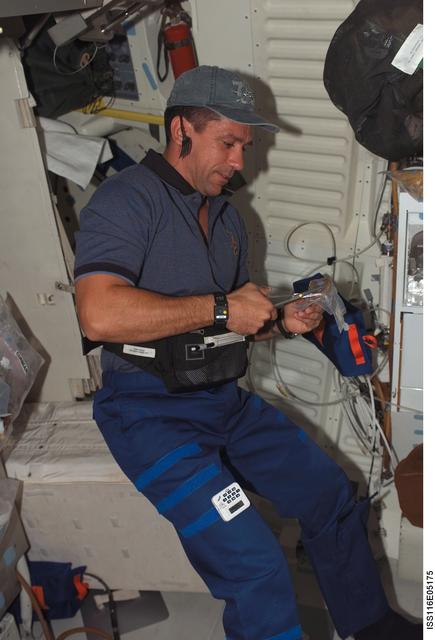 STS-116 ESA Fuglesang opens food article in the FD on Space Shuttle Discovery