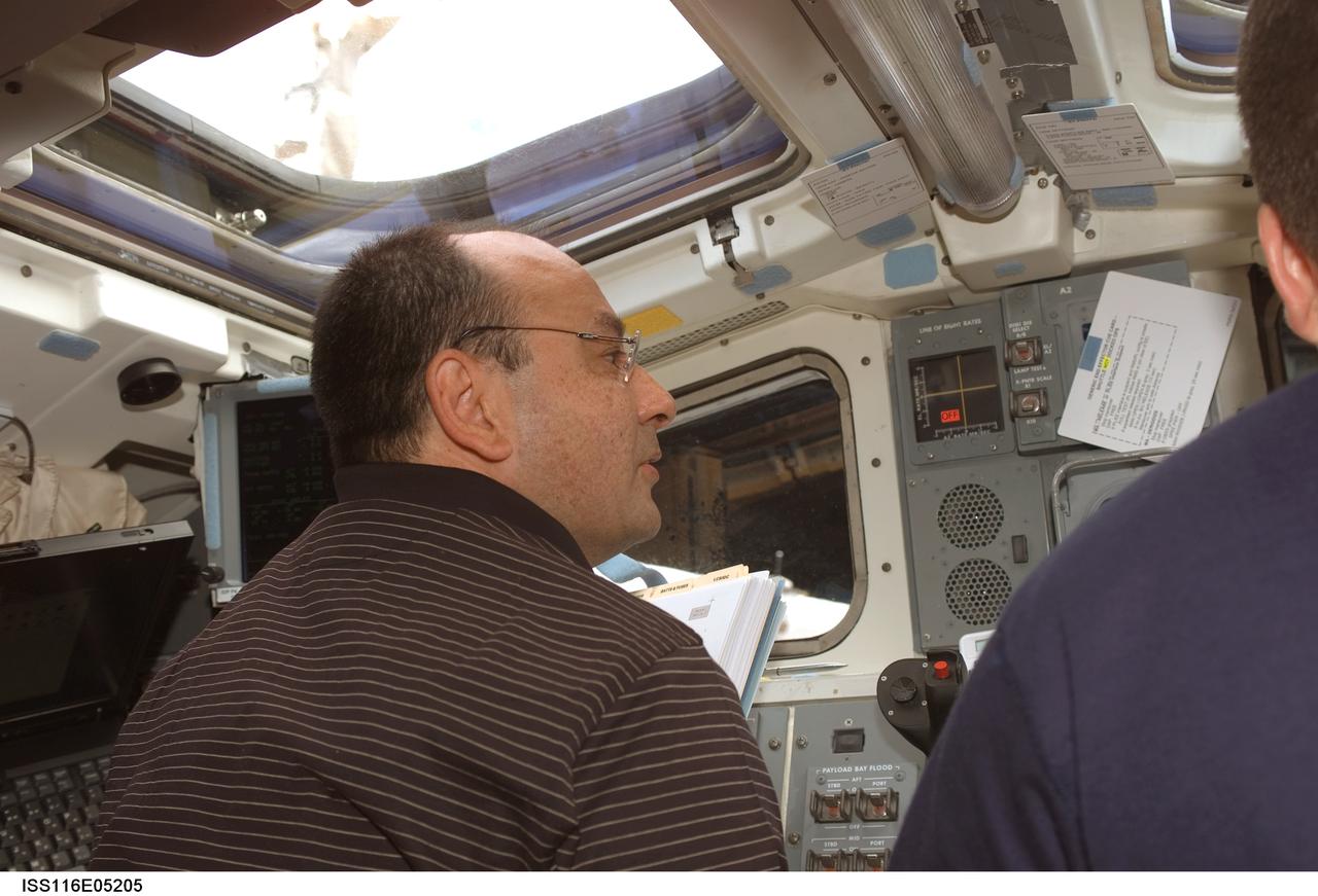S116-E-05205 (10 Dec. 2006) --- Astronaut Mark L. Polansky, STS-116 commander, works the controls on the aft flight deck of Space Shuttle Discovery during flight day two activities.