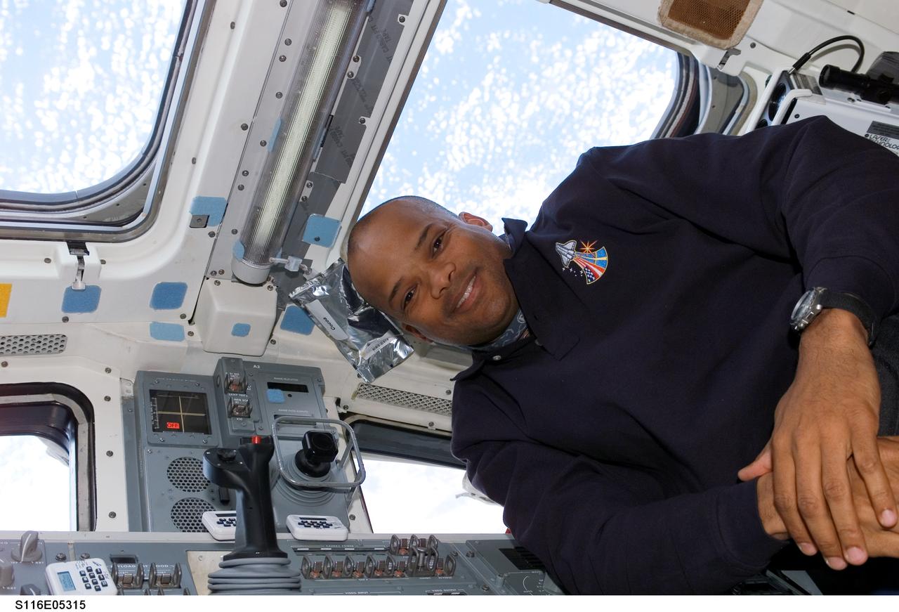 S116-E-05315 (10 Dec. 2006) --- Astronaut Robert L. Curbeam, Jr., STS-116 mission specialist, floats near the controls and windows on the aft flight deck of Space Shuttle Discovery.