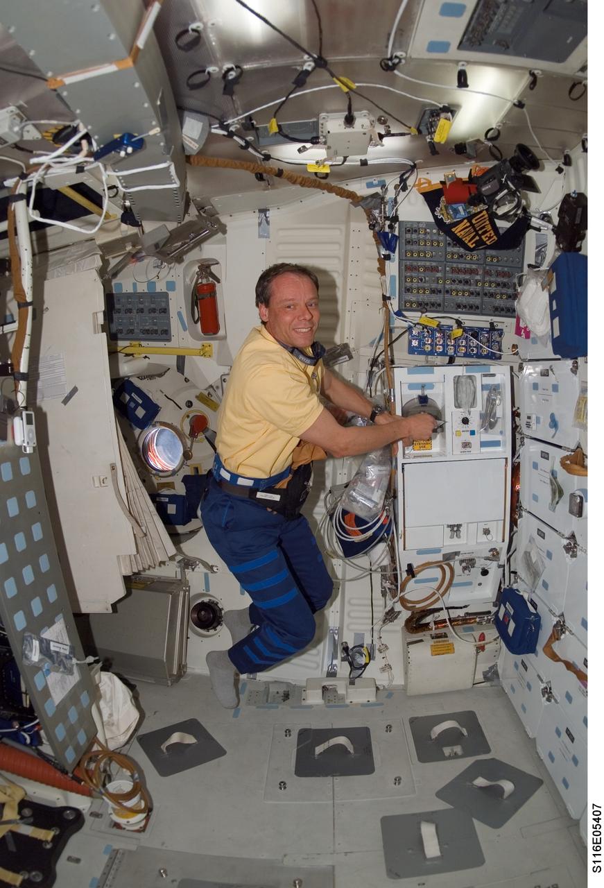 S116-E-05407 (11 Dec. 2006) --- European Space Agency (ESA) astronaut Christer Fuglesang, STS-116 mission specialist, prepares a meal at the galley on the middeck of Space Shuttle Discovery.