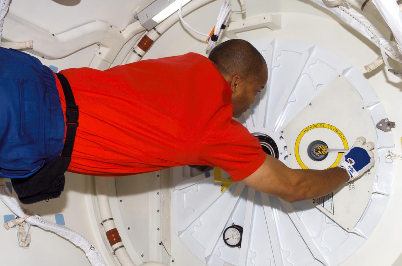 S116-E-05569 (11 Dec. 2006) --- Astronaut Robert L. Curbeam, Jr., STS-116 mission specialist, prepares to open the hatch that will lead the entire Space Shuttle Discovery crew into the International Space Station. This was just one highlight of a very busy day that earlier saw the flawless rendezvous and docking operations between the shuttle and station. Docking occurred at 4:12 p.m. (CST) and the crew entered the orbital outpost at 5:54 p.m. (CST) on Dec. 11.