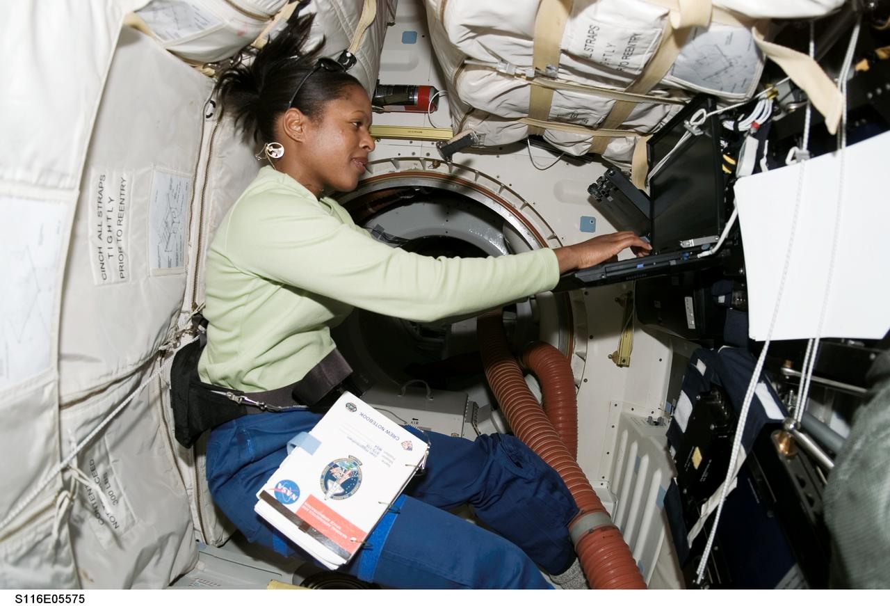 S116-E-05575 (11 Dec. 2006) --- Astronaut Joan E. Higginbotham, STS-116 mission specialist, uses a computer on the middeck of Space Shuttle Discovery during flight day three activities.