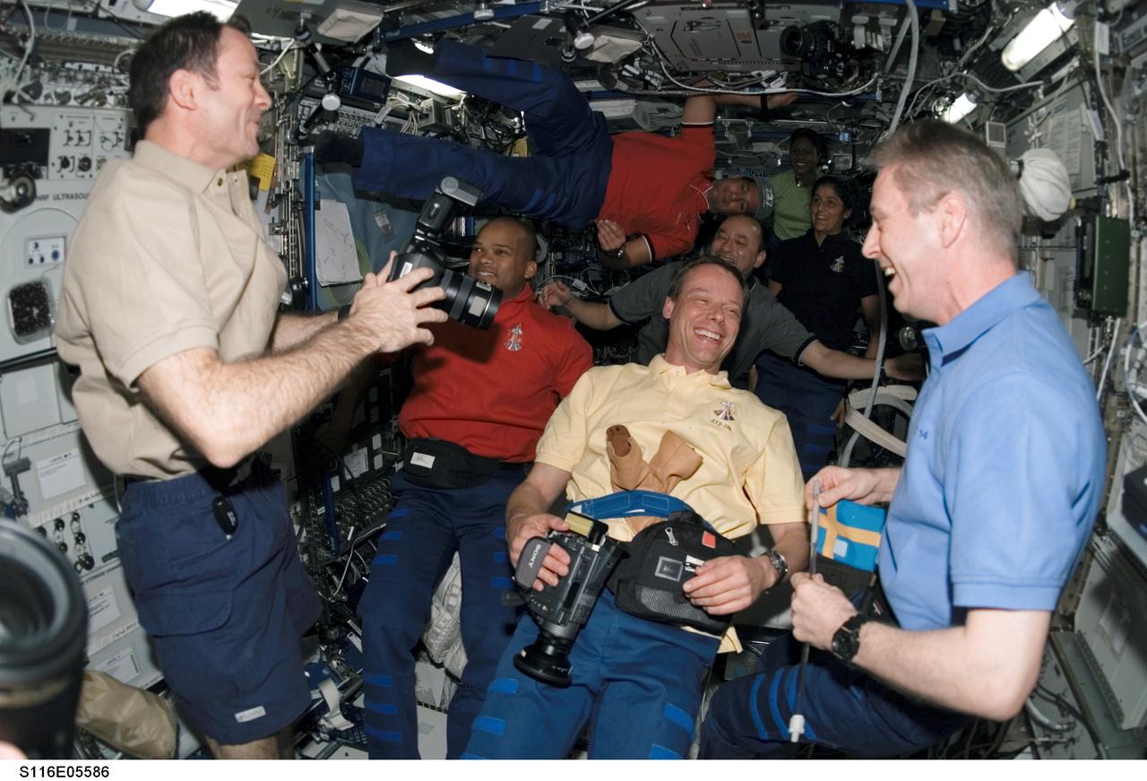 S116-E-05586 (11 Dec. 2006) --- The Space Shuttle Discovery and Expedition 14 crewmembers enjoy a light moment in the Destiny laboratory of the International Space Station following rendezvous and docking operations between the shuttle and station. Pictured in the foreground (left to right) are astronauts Michael E. Lopez-Alegria, Expedition 14 commander and NASA space station science officer; European Space Agency (ESA) astronauts Christer Fuglesang, STS-116 mission specialist; and Thomas Reiter, Expedition 14 flight engineer. Pictured in the background are astronauts Robert L. Curbeam, Jr., STS-116 mission specialist; Mark L. Polansky, STS-116 commander; William A. (Bill) Oefelein, STS-116 pilot; Joan E. Higginbotham and Sunita L. Williams, both STS-116 mission specialists.