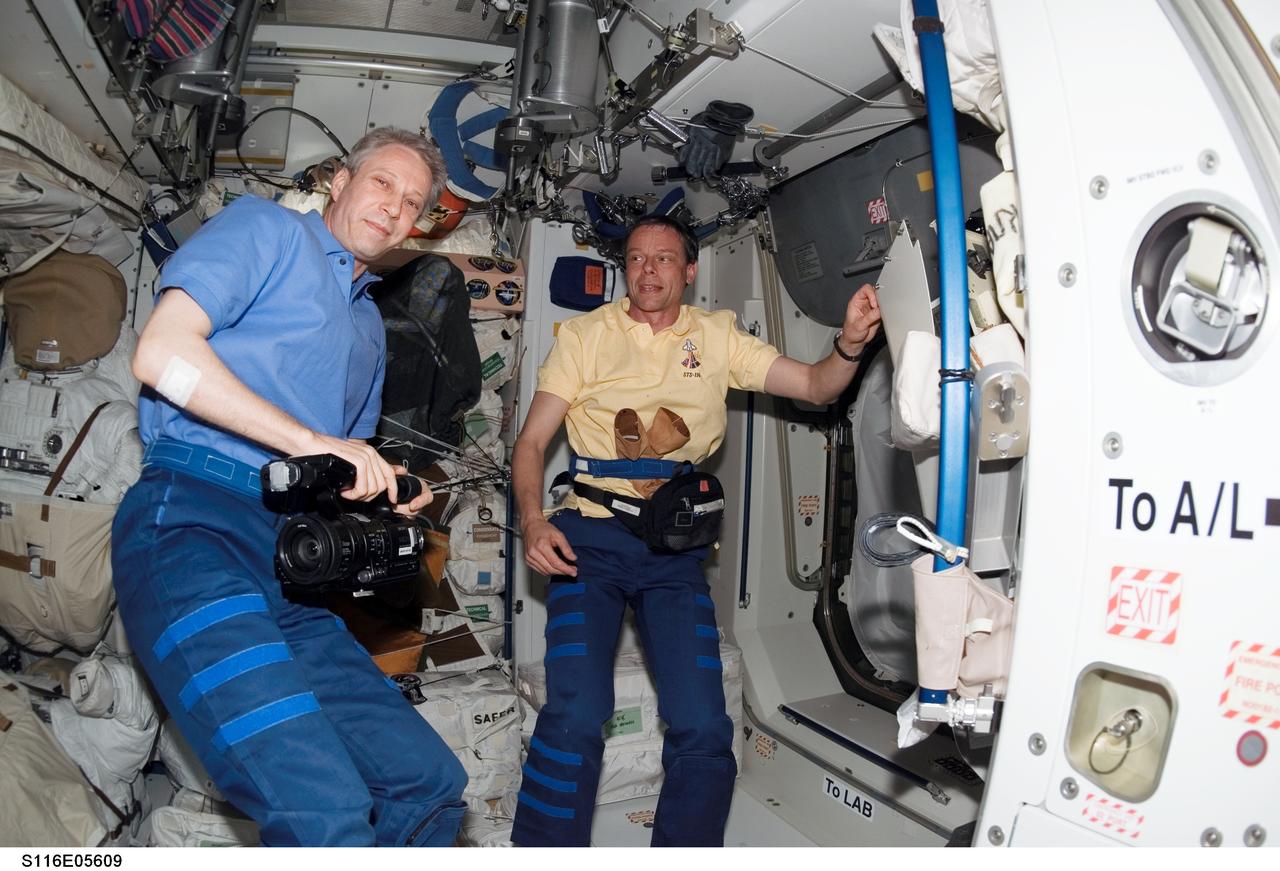 S116-E-05609 (11 Dec. 2006) --- European Space Agency (ESA) astronauts Thomas Reiter (left), Expedition 14 flight engineer, and Christer Fuglesang, STS-116 mission specialist, discuss an approaching task in the International Space Station following a successful rendezvous and docking between the station and shuttle.