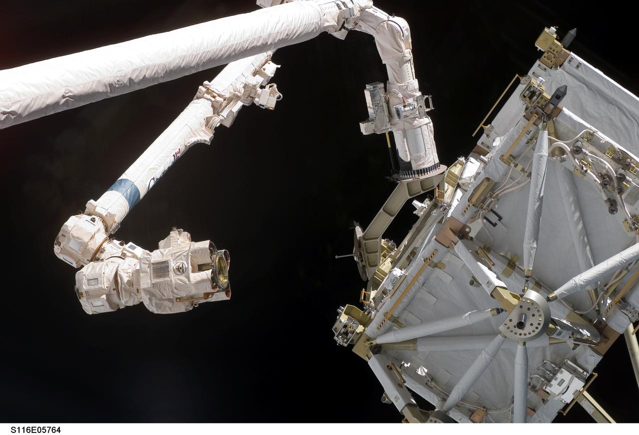 S116-E-05764 (11 Dec. 2006) --- The International Space Station's Canadarm2 moves toward the station's new P5 truss section for a hand-off from Space Shuttle Discovery's Remote Manipulator System (RMS) robotic arm.