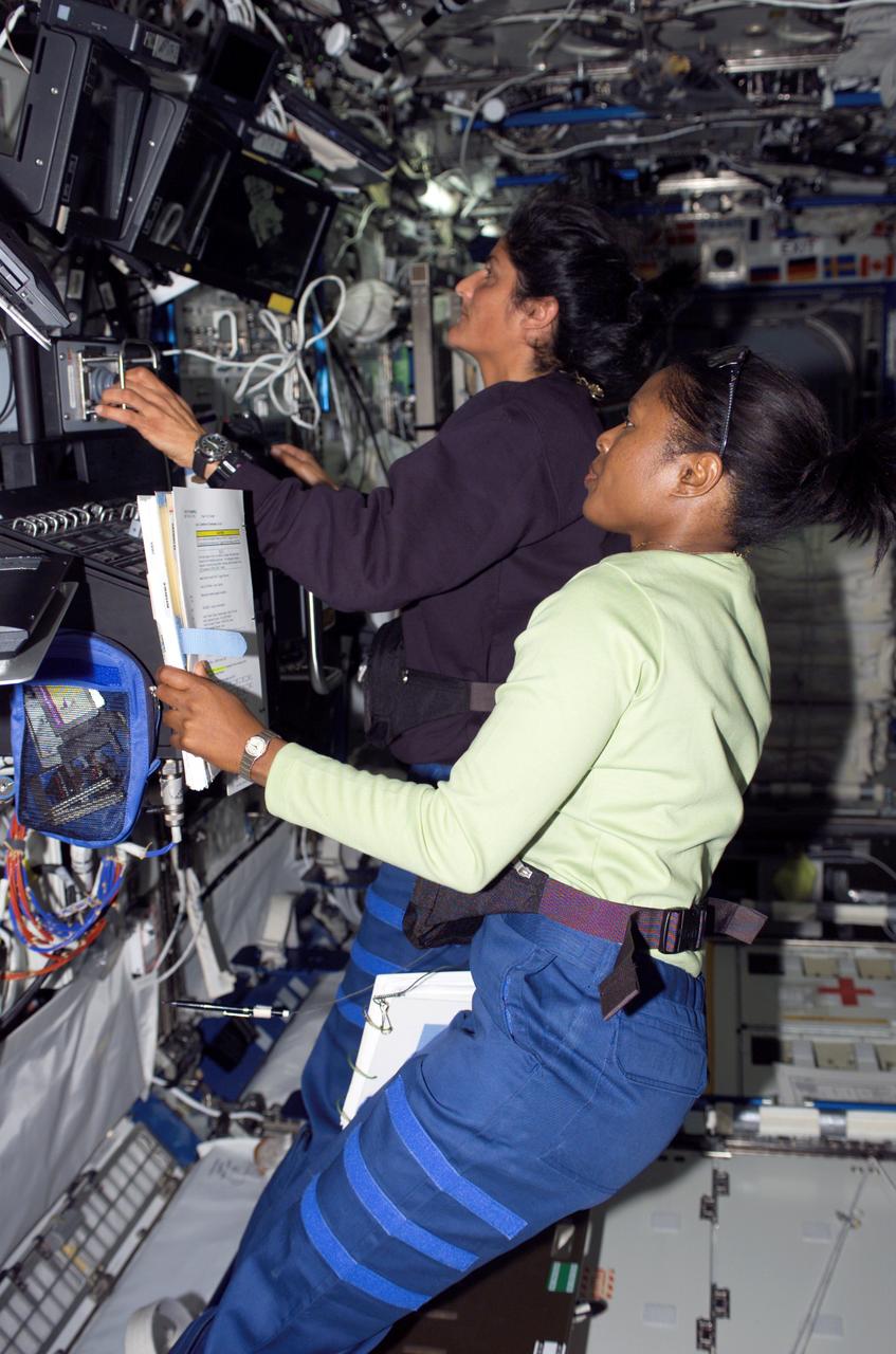 S116-E-05777 (11 Dec. 2006) --- Astronauts Joan E. Higginbotham (foreground) and Sunita L. Williams, both STS-116 mission specialists, work the controls of the Space Station Remote Manipulator System (SSRMS) or Canadarm2 in the Destiny laboratory of the International Space Station during flight day three activities.