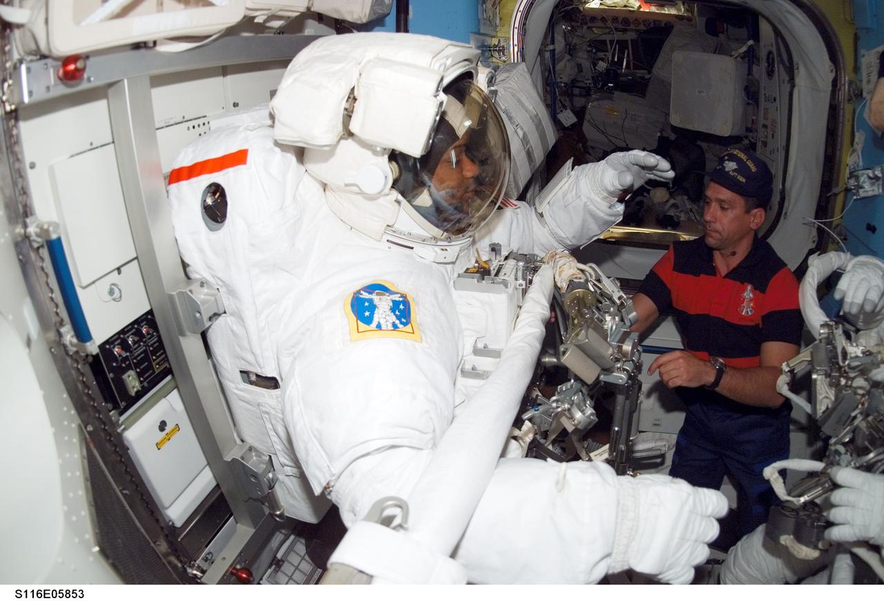 S116-E-05853 (12 Dec. 2006) --- Attired in his extravehicular mobility unit (EMU) spacesuit, astronaut Robert L. Curbeam, Jr., STS-116 mission specialist, prepares for the mission's first session of extravehicular activity (EVA) in the Quest Airlock of the International Space Station while Space Shuttle Discovery was docked with the station. Astronaut William A. (Bill) Oefelein, pilot, assisted Curbeam.