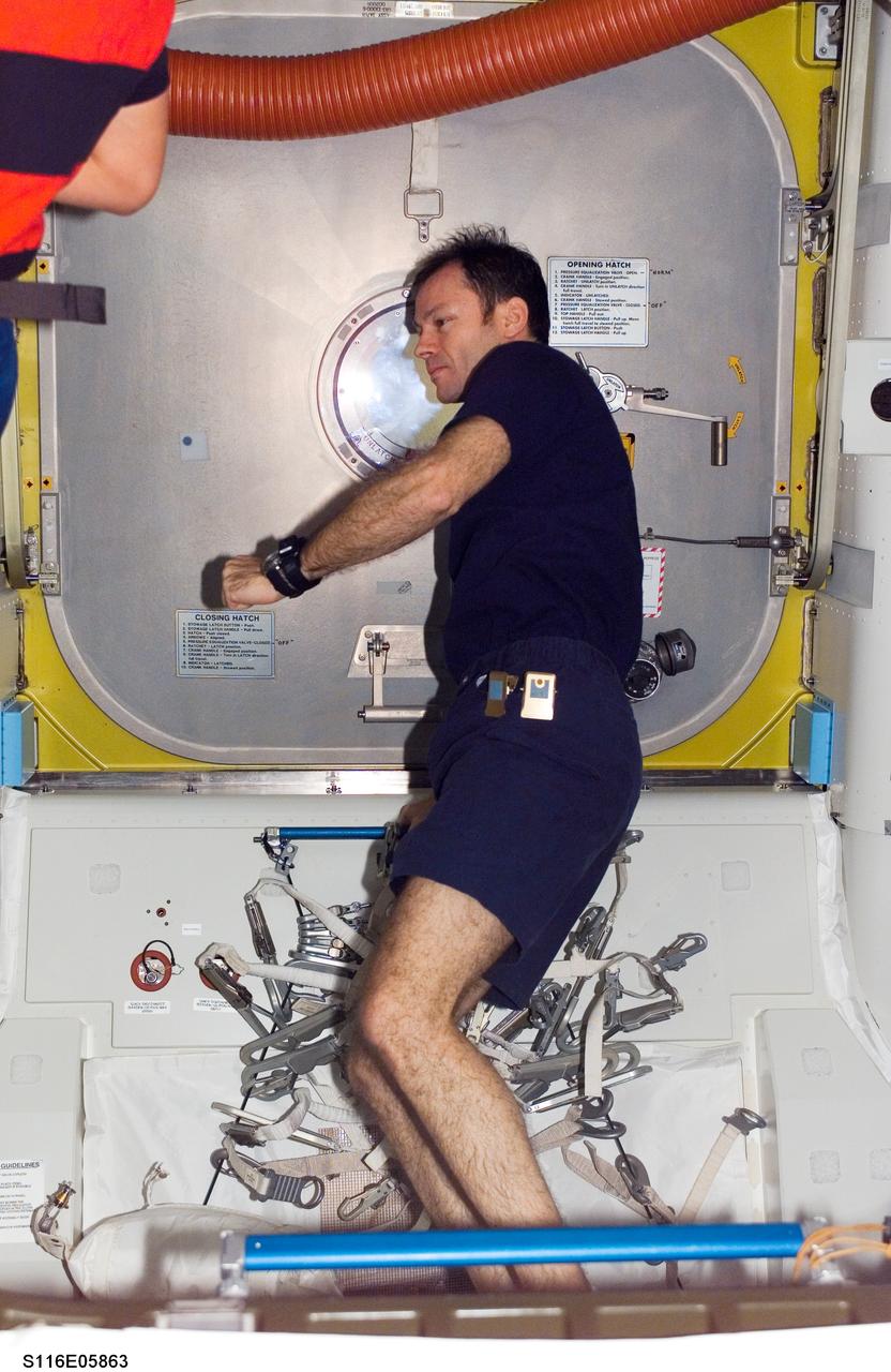 S116-E-05863 (12 Dec. 2006) --- Astronaut Michael E. Lopez-Alegria, Expedition 14 commander and NASA space station science officer, closes the interior hatch to the Quest Airlock of the International Space Station. Astronaut Robert L. Curbeam, Jr. and European Space Agency (ESA) astronaut Christer Fuglesang, both STS-116 mission specialists, were about to exit the airlock for the mission's first session of extravehicular activity (EVA).