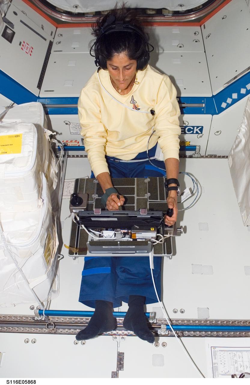 S116-E-05868 (12 Dec. 2006) --- Astronaut Sunita L. Williams, Expedition 14 flight engineer, works with the Perceptual Motor Deficits in Space (PMDIS) experiment in the Destiny laboratory of the International Space Station. The PMDIS experiment will measure the decline in hand-eye coordination of shuttle astronauts while on orbit. These measurements will be used to evaluate various mechanisms thought to be responsible for the decline.