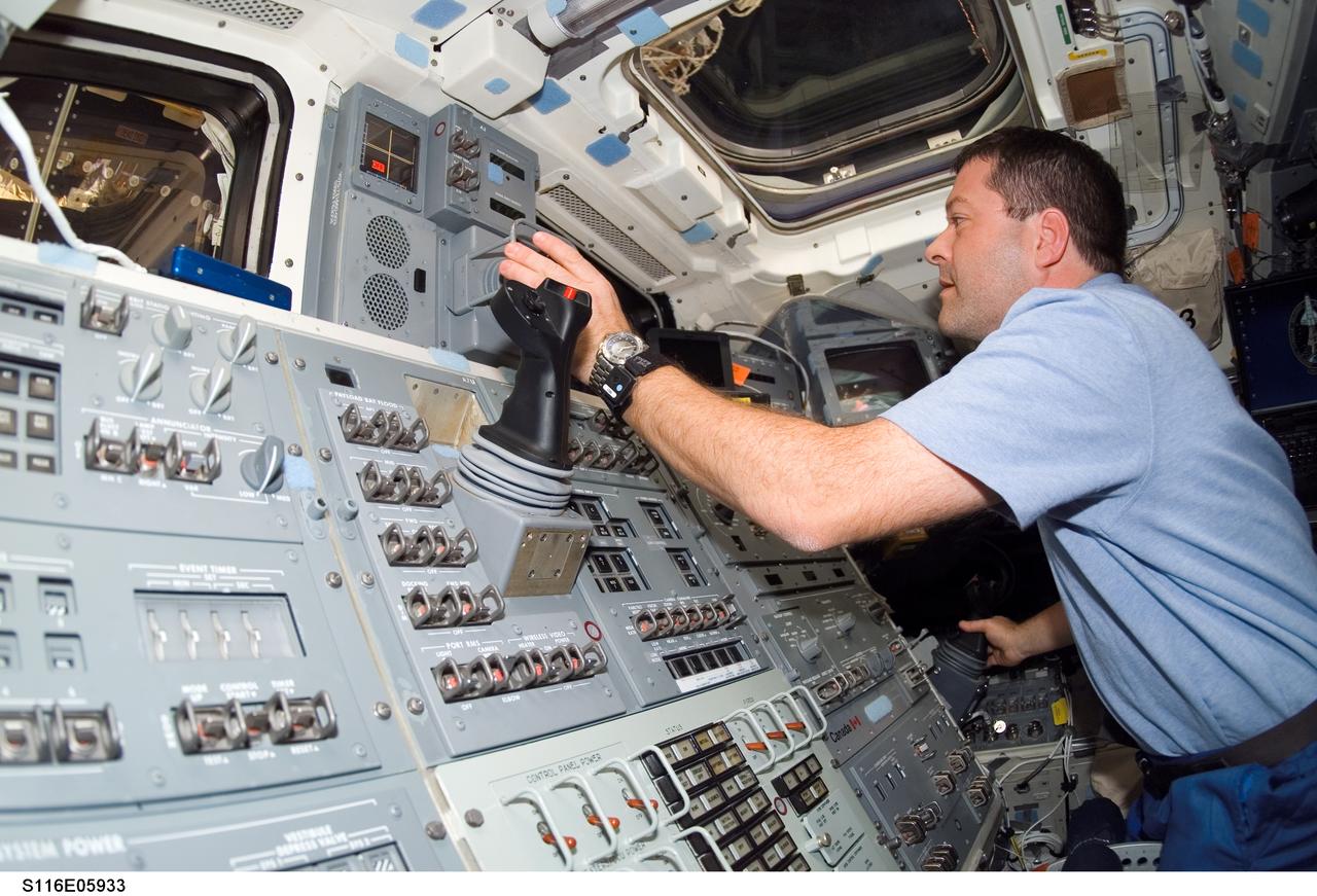 S116-E-05933 (12 Dec. 2006) --- Astronaut Nicholas J. M. Patrick, STS-116 mission specialist, works the controls on the aft flight deck of Space Shuttle Discovery during flight day four activities.